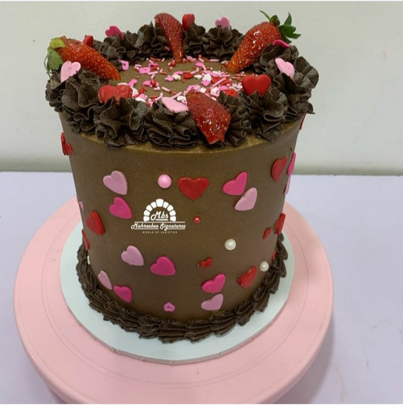 valentine cake with chocolate icing topped with strawberries