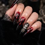 black Halloween nails featuring blood-red drips and a glittery Chucky accent nail